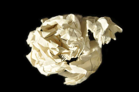 Crumpled beige cardboard paper ball in office, isolated on black backgroundの写真素材