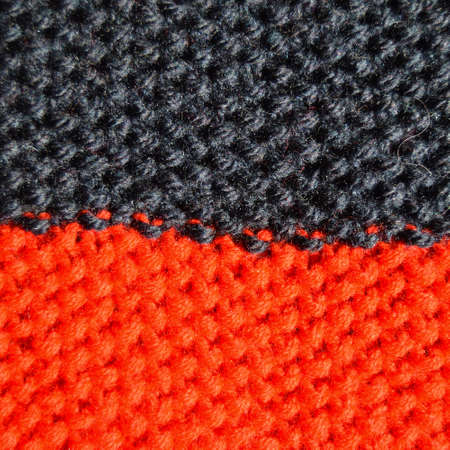 Pattern fabric made of wool. Handmade knitted fabric red and navy wool background texture