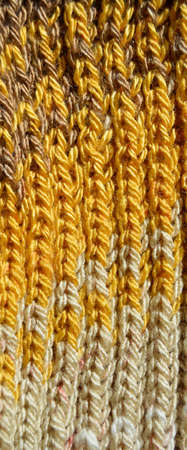 Pattern fabric made of wool. Handmade knitted fabric yellow wool background texture