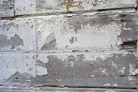Cracked peeled white paint background on old wooden floor, cracked weathered paint patternの写真素材