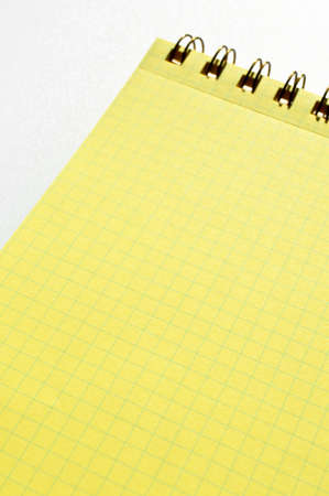 Wire spiral unlined clean yellow checkered lined paper isolated on white backgroundの写真素材