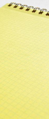 Wire spiral unlined clean yellow checkered lined paper isolated on white background
