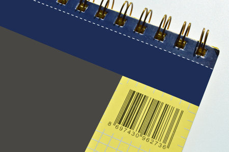 Wire spiral unlined clean yellow gray blue checkered lined paper isolated on white backgroundの写真素材