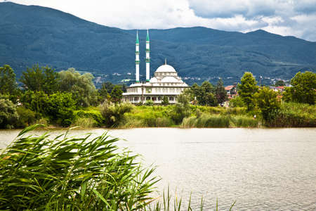 White mosque by the lake, mountain view among green reeds, location Sakarya Akyazi Turkeyの写真素材