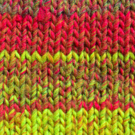 Pattern fabric made of wool. Handmade knitted fabric red and yellow wool background textureの写真素材