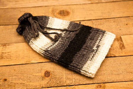 Handmade wool knitted winter gray and whitehat isolated on wooden background