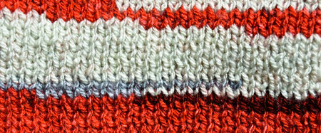 Pattern fabric made of wool. Handmade knitted fabric red and white wool background texture