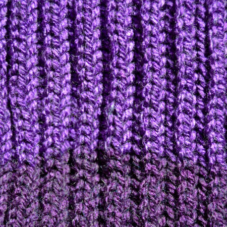 Pattern fabric made of wool. Handmade knitted fabric purple wool background texture