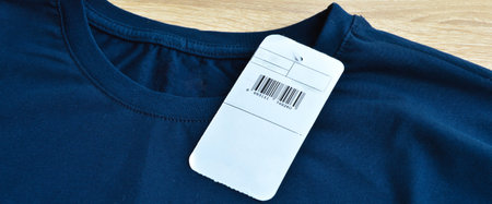 New navy blue t-shirt and blank label, on wooden floorの写真素材