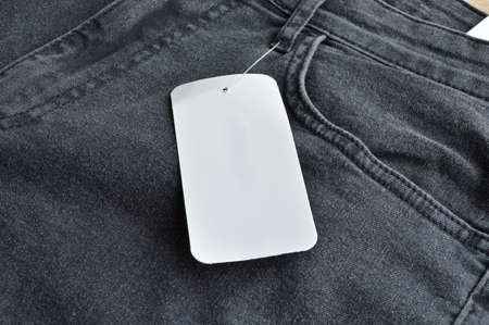 Zipper and pocket black jeans denim and blank empty sale tag paperの写真素材