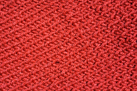 Pattern fabric made of wool. Handmade knitted fabric red wool background texture