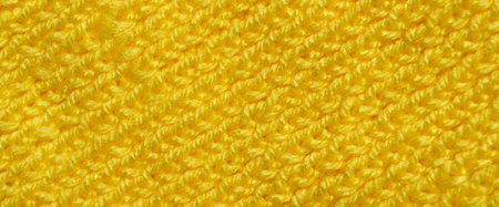 Pattern fabric made of wool. Handmade knitted fabric yellow wool background texture