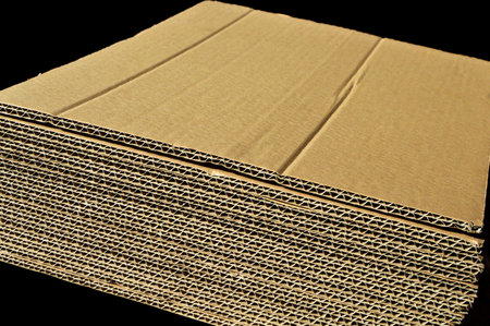 Brown and beige colored corrugated cardboard detail, isolated on black background