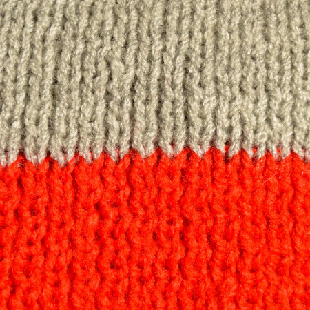 Pattern fabric made of wool. Handmade knitted fabric red and gray wool background textureの写真素材