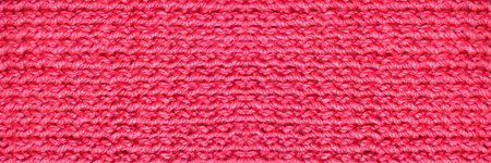 Pattern fabric made of wool. Handmade knitted fabric pink and red wool background textureの写真素材