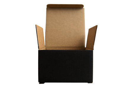 Closed black rectangular cardboard box with corrugated cardboard lid and hand on oak wooden table