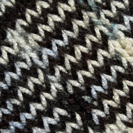 Pattern fabric made of wool. Handmade knitted fabric white brown wool background texture