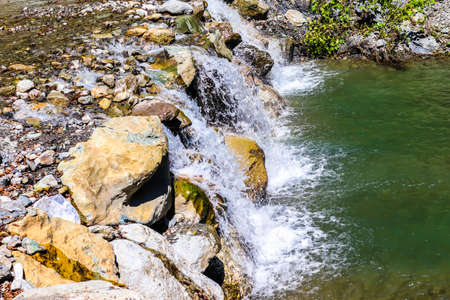 Waterfall in the mountains. Mountain landscape. Mountain river. Mountain river.