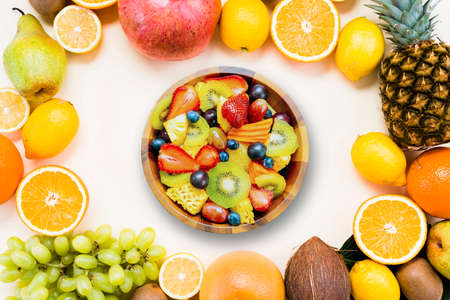 Fruit salad in a wooden bowl with fresh fruits. Top view.の写真素材