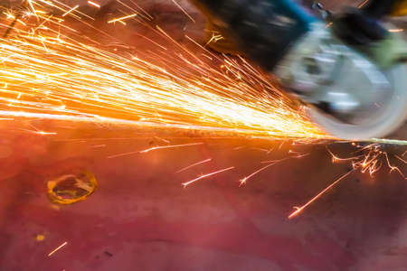 Sparks from cutting metal with electric arc grinder machine.