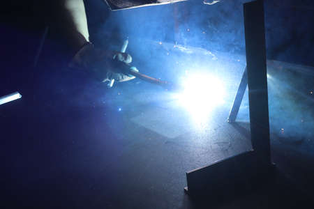 Welding work. The welder welds metal at the factory.