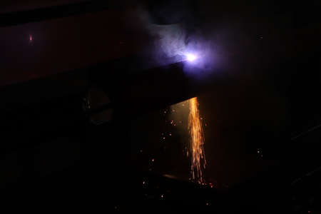 Sparks while welder working with arc welding machine at construction site