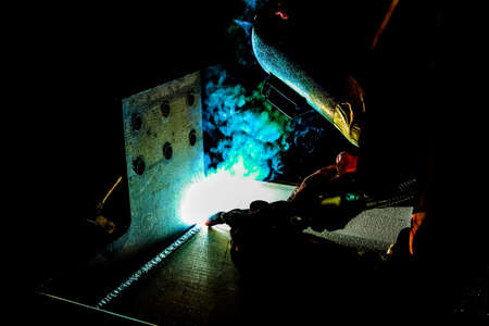 welder at work, close-up, sparks fly in different directions