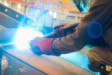 Welding work at the factory. The welder welds metal.