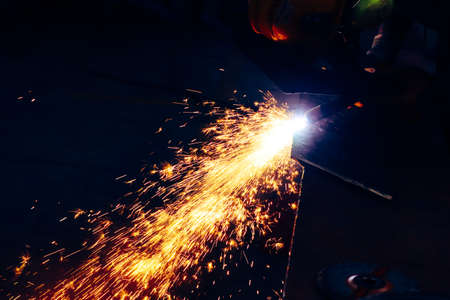 sparks while welder works with electric arc welding machine.