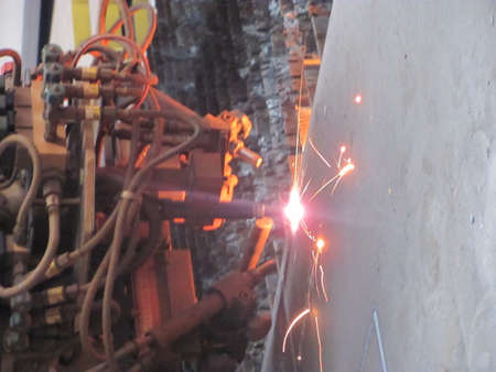 Welding work in a factory. Sparks fly out of the welding machine.