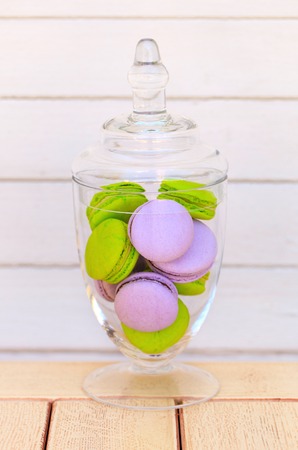 Delicious sweet buffet with colorful glass bowl of macaronsの写真素材