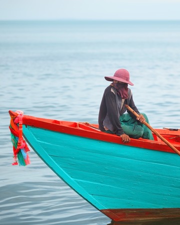 Traditional asian fishing. Cambodian man on the fishing boatの写真素材