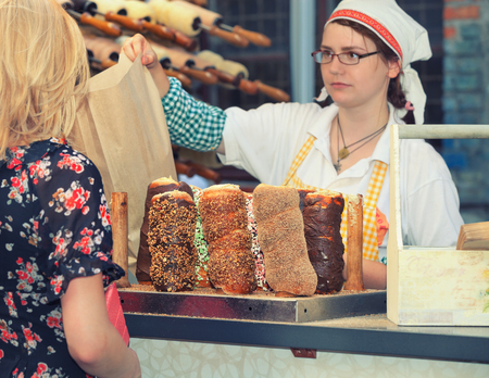 Budapest, Hungary - December 2013: Hungarian woman selling traditional chimney cakesのeditorial素材