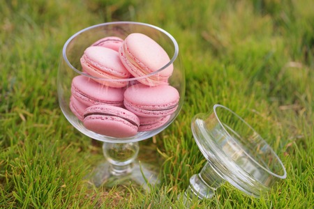 Delicious sweet buffet with colorful glass bowl of macaronsの写真素材