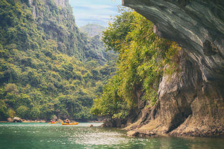 Yellow kayaks on turquoise sea water in the cave of Halong Bayの写真素材