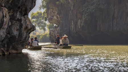 Tam Coc, Ning Bihn province, Vietnam - December 19, 2014: tourists sailing on a river with vietnamese guide through the caveのeditorial素材