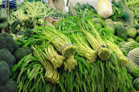 Traditional asian market with fresh exotic vegetables and herbs