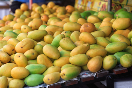 Traditional asian market stall full of fresh mangoesの写真素材