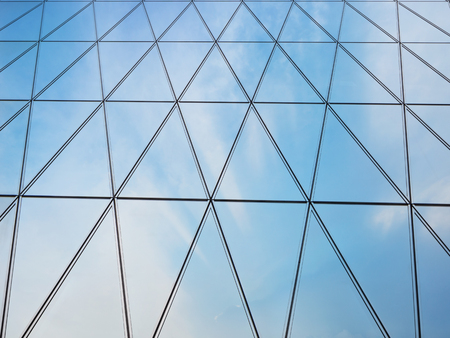 Abstract close-up view of modern facade of triangles with sky reflectionの写真素材