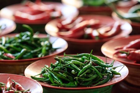 Traditional asian market with fresh green and red chili pepperの写真素材