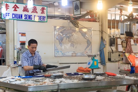 Singapore, Republic of Singapore - May 5, 2016: asian man selling fresh fish at traditional market stallのeditorial素材