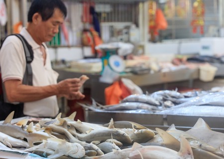 Singapore, Republic of Singapore - May 5, 2016: asian man buying fresh fish at traditional market stallのeditorial素材