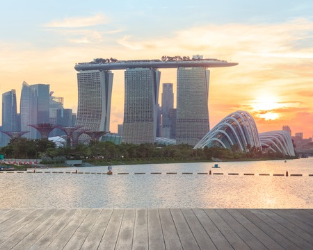 Singapore, Republic of Singapore - May 4, 2016: Supertree grove, Cloud garden greenhouse and Marina Bay Sands at sunset with wooden decks on foreground. View from Marina East parkのeditorial素材