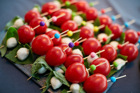 stuffed tomato with cheese on black plateの写真素材
