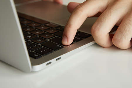 a man working on a laptop, his hands close up
