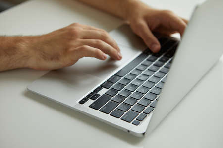 a man working on a laptop, his hands close upの写真素材