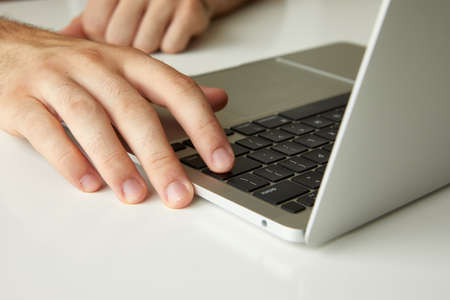 a man working on a laptop, his hands close upの写真素材