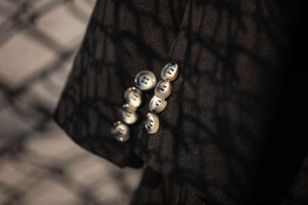 fragment of a sleeve with buttons of a black coatの写真素材