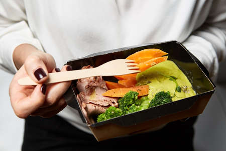 a box of food in the hands of a waiter during cateringの写真素材