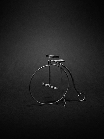 Old fashioned bicycle on black background. Minimalistic still life.の写真素材